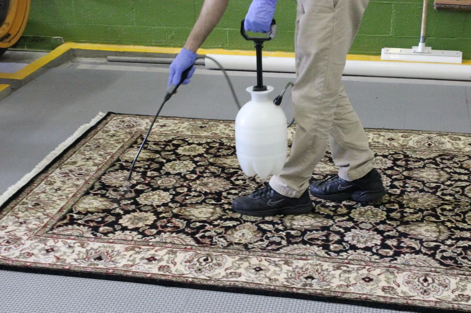 Pre-spray being applied to an Oriental rug on the wash floor
