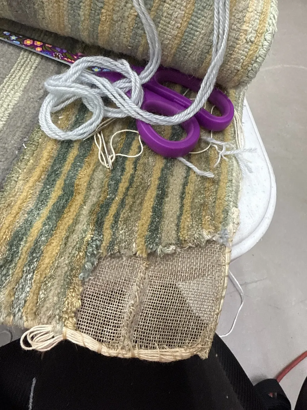 Worn area on a cream and green shaggy wool rug